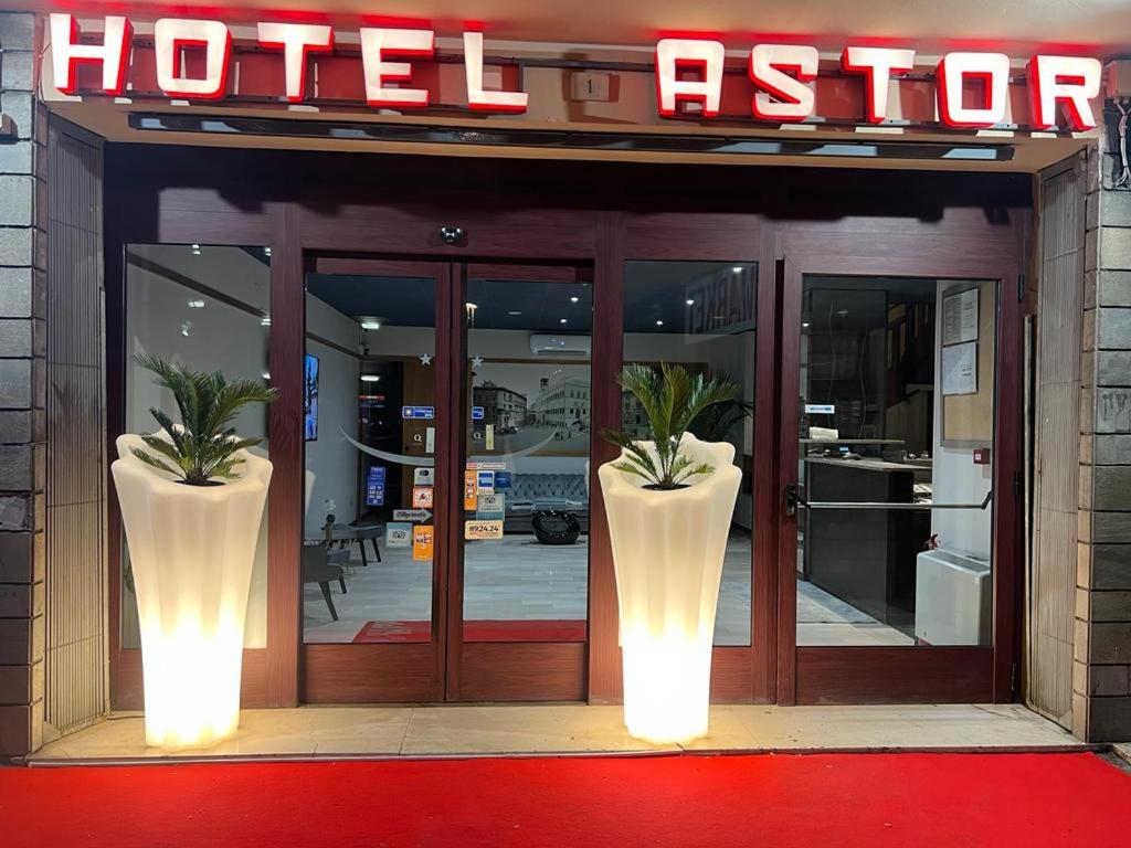 佩鲁贾Hotel Astor的酒店入口前面有两根大花瓶