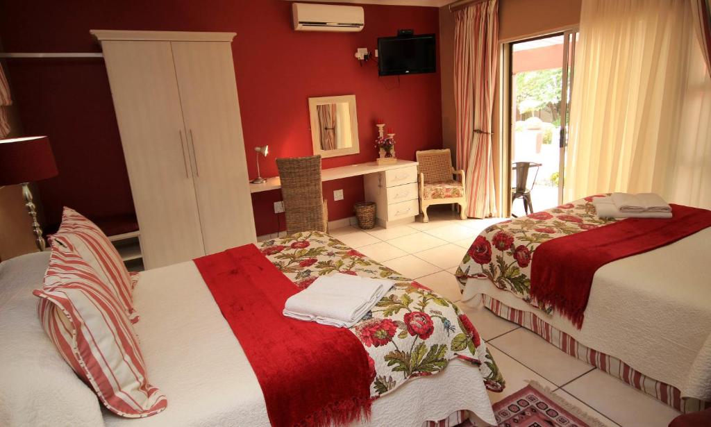 纽卡斯尔阿瓦隆旅馆的一间卧室配有两张床和一张带镜子的书桌