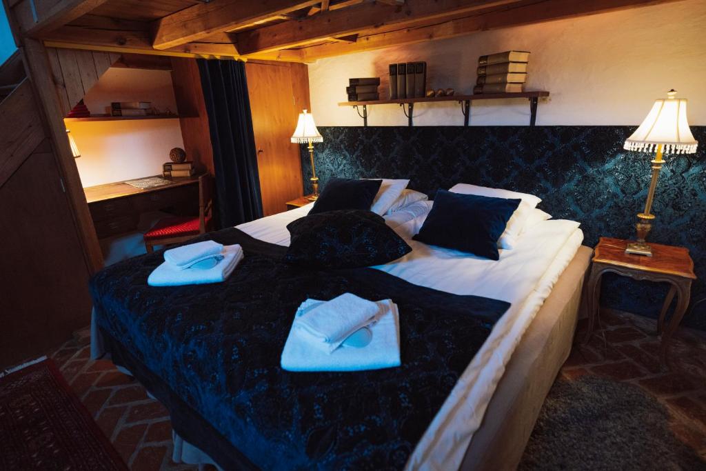 韦克舍特里博格斯洛特酒店的一间卧室配有一张大床,上面有蓝色的毛巾