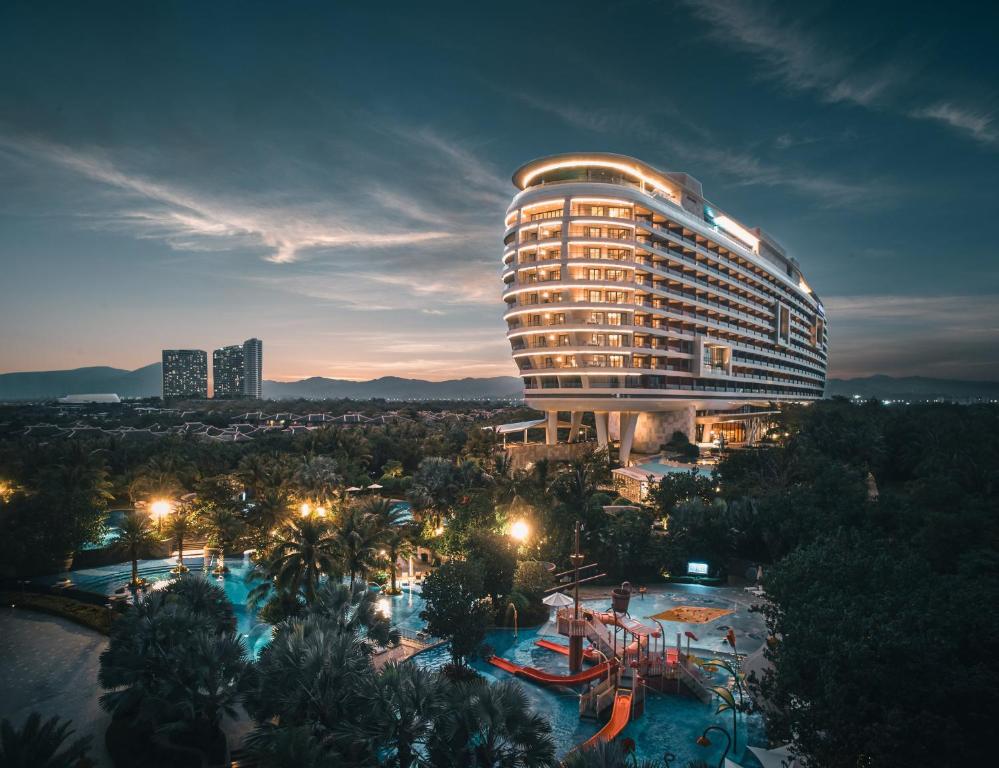 三亚三亚海棠湾仁恒皇冠假日度假酒店（网红无边际泳池）的一座大型建筑,前面设有一个游泳池
