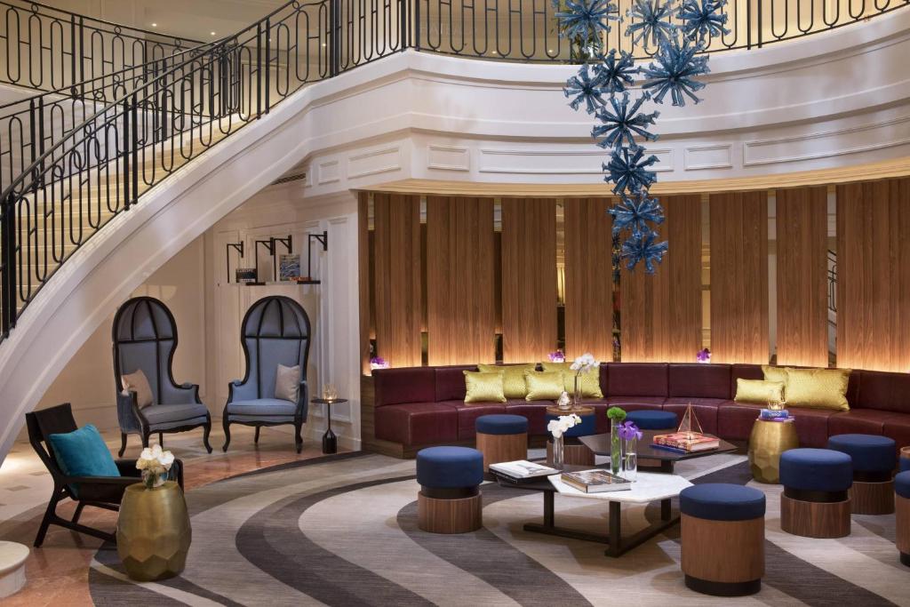 皮托巴黎拉德芳斯万丽酒店的一个带沙发和椅子的大堂和一个楼梯