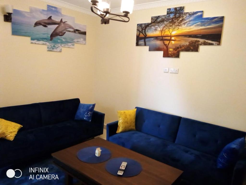 内罗毕Neema Court Jamhuri-woodly的客厅配有2张蓝色的沙发和1张桌子