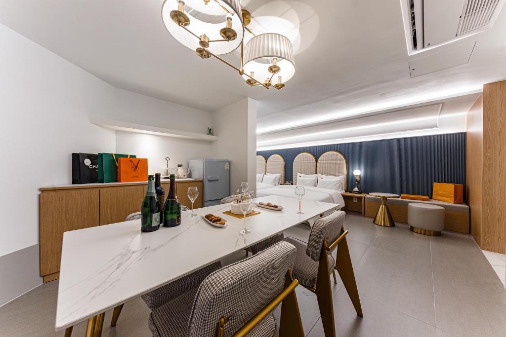 天安市Brown Dot Hotel Cheonan Buldang的一间配备有白色桌椅的用餐室