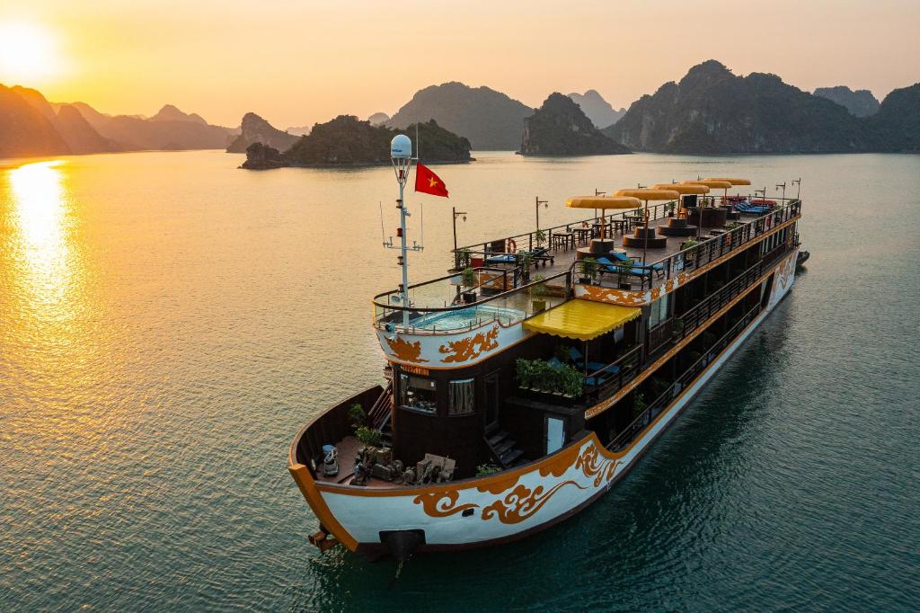 下龙湾Nostalgia Halong Cruise的日落时分在水中乘坐渡船