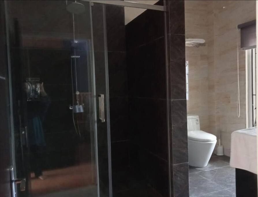 TimuranINEZ Homestay Prawirotaman Yogya的一间带卫生间的浴室内的玻璃淋浴间