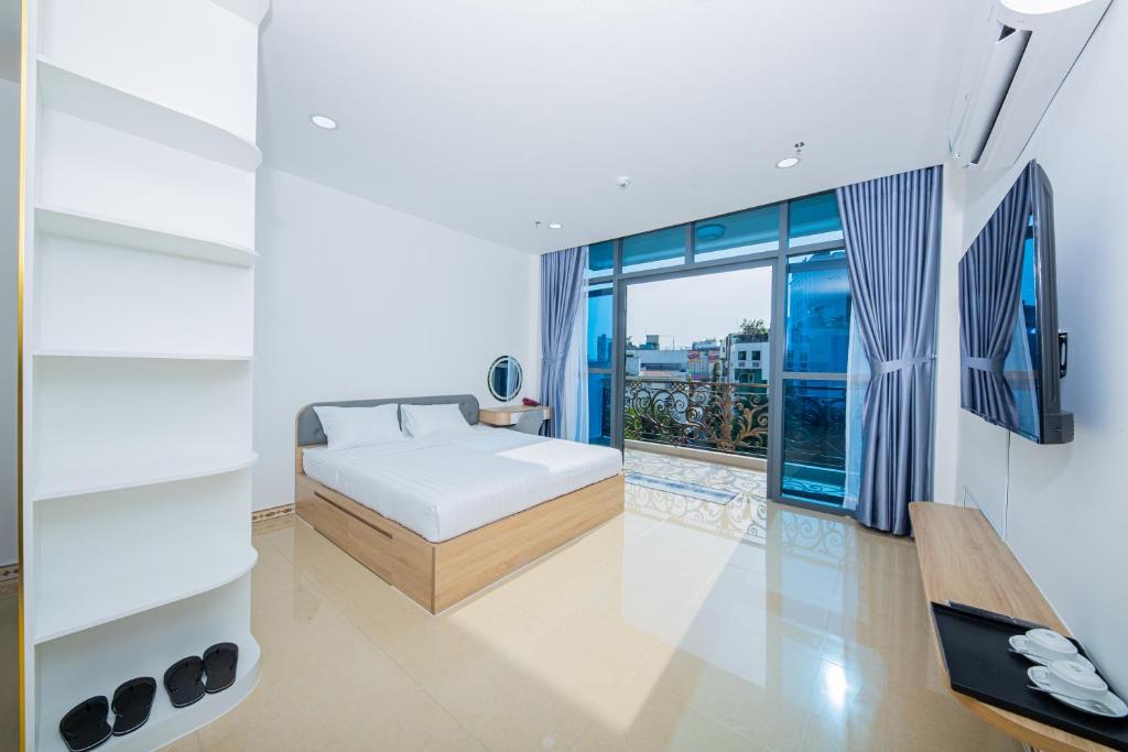胡志明市Chanh Huy Apartments & Hotel的一间卧室设有一张床和一个大窗户