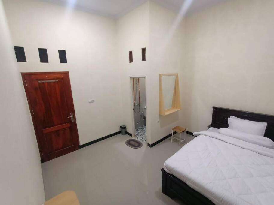 井里汶Anugrah homestay的一间卧室配有一张床和一扇木门