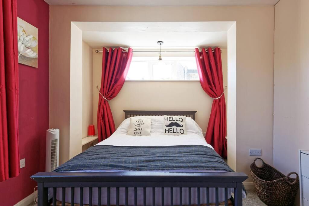 马盖特Garden Oasis的一间卧室配有一张带红色窗帘的床和一扇窗户