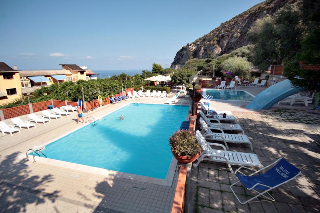 梅塔布鲁村酒店的一个带椅子和滑梯的大型游泳池