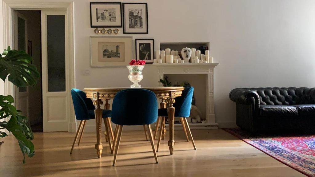 米兰Bohemian House的一间带桌子和蓝色椅子的用餐室