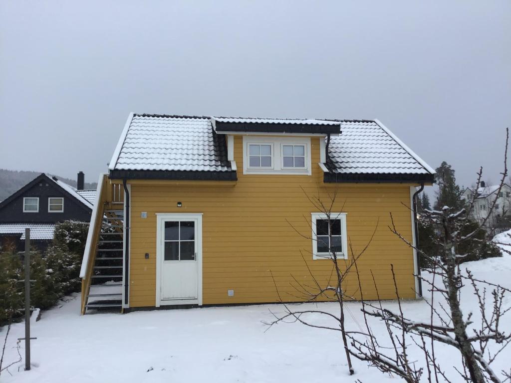 沃斯Sandvik Garasjeloft的雪中的一个黄色小房子