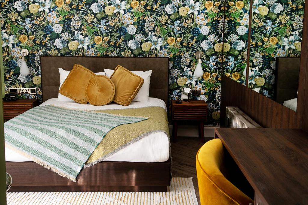 拉格比德雷科特酒店&怀特菲尔德高尔夫球场的一间卧室配有一张带花卉壁纸的床