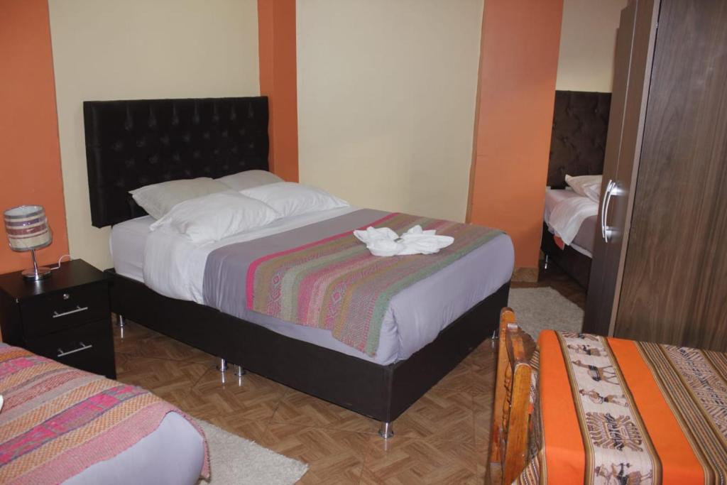 奥兰太坦波hostal Qorisonqo inn ollantaytambo的一间卧室,配有一张带鲜花的床