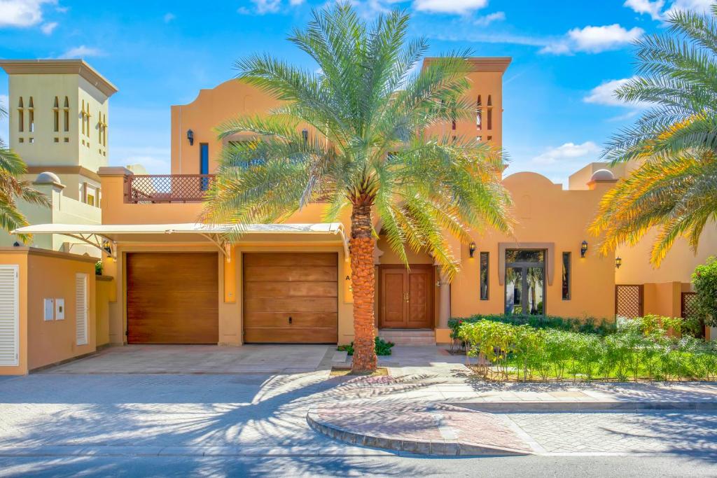 迪拜FAM Living - Palm Jumeirah - Beach Villas with Private Pool的房屋前的棕榈树