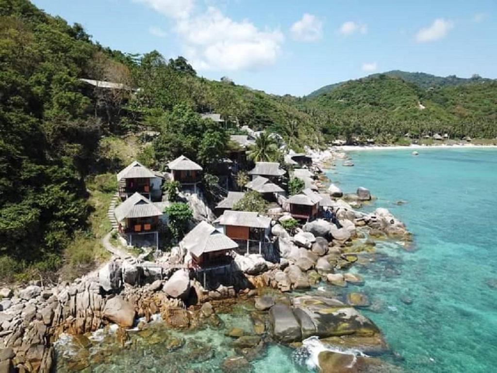 涛岛OK2 Mamajim Bungalows的一座拥有小屋和海洋的岛屿