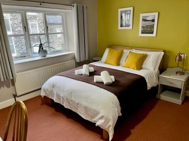 肯德尔Courtyard Flat - Kendal的一间卧室配有一张床,上面有两条毛巾