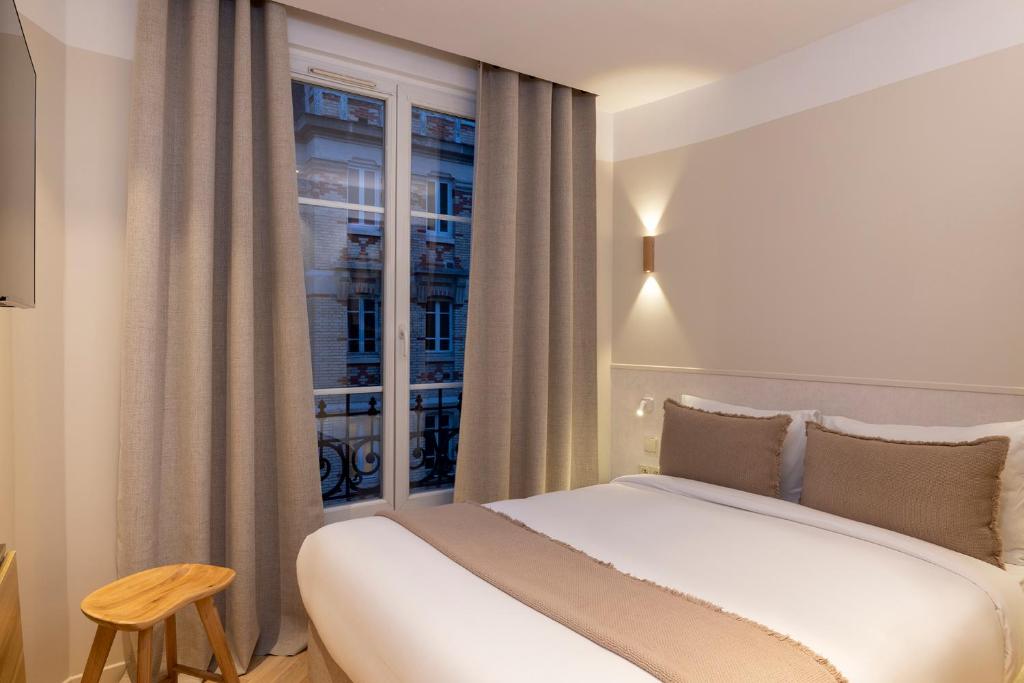 巴黎Hôtel Le Daum的卧室配有白色的床和窗户。