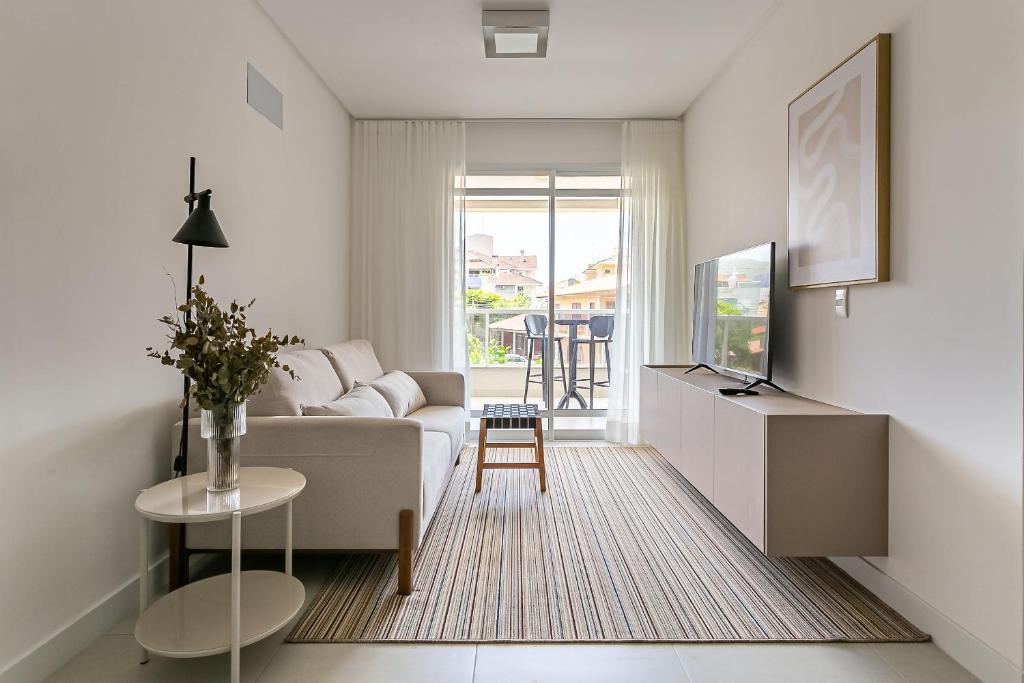 弗洛里亚诺波利斯Cannes Club Residence a 200m da praia, recém inaugurado的白色的客厅配有沙发和桌子