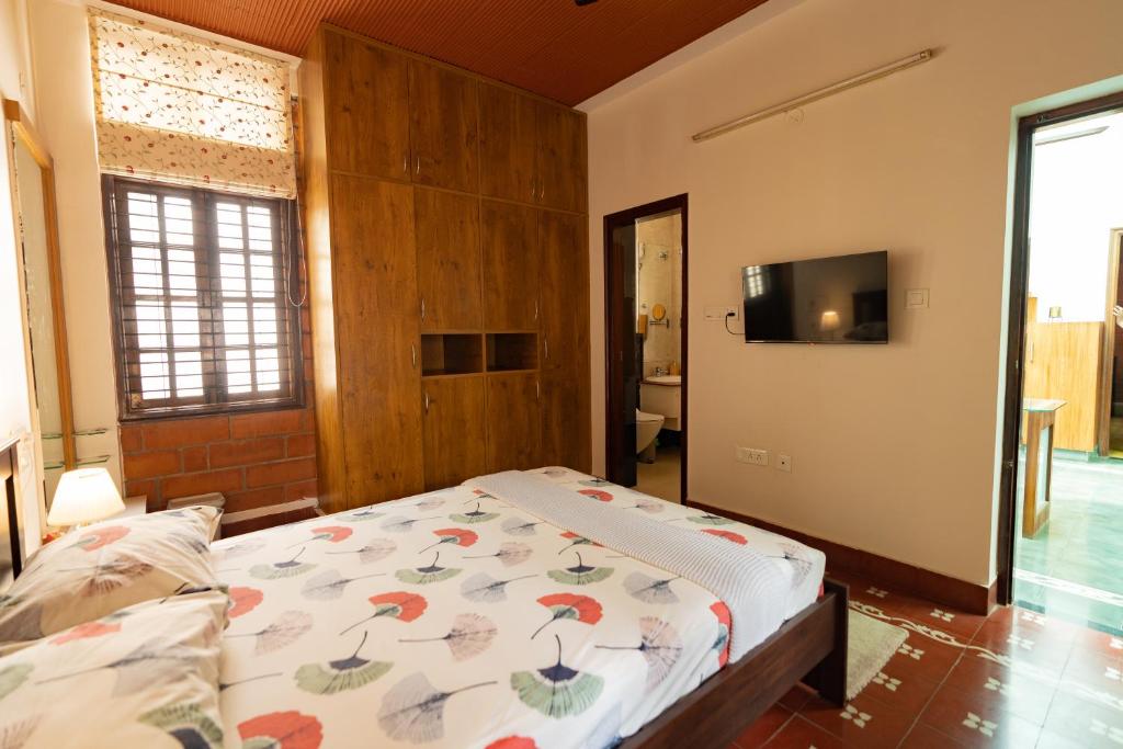 班加罗尔Luho 25 Whitefield的一间卧室配有一张床和一台平面电视