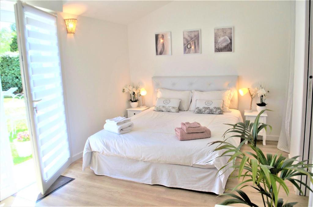 锡富尔勒普拉日Chambre d'hôtes de charme MERBLEUESOLEIL的白色的卧室设有白色的床和窗户。