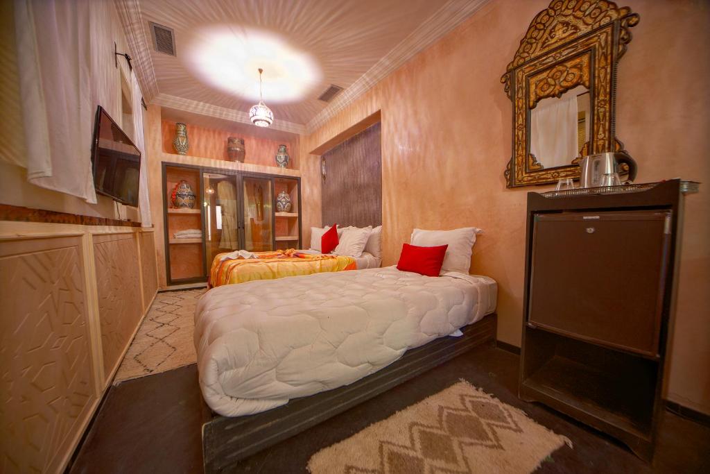 瓦尔扎扎特Riad Tama & spa的一间卧室配有两张床和镜子