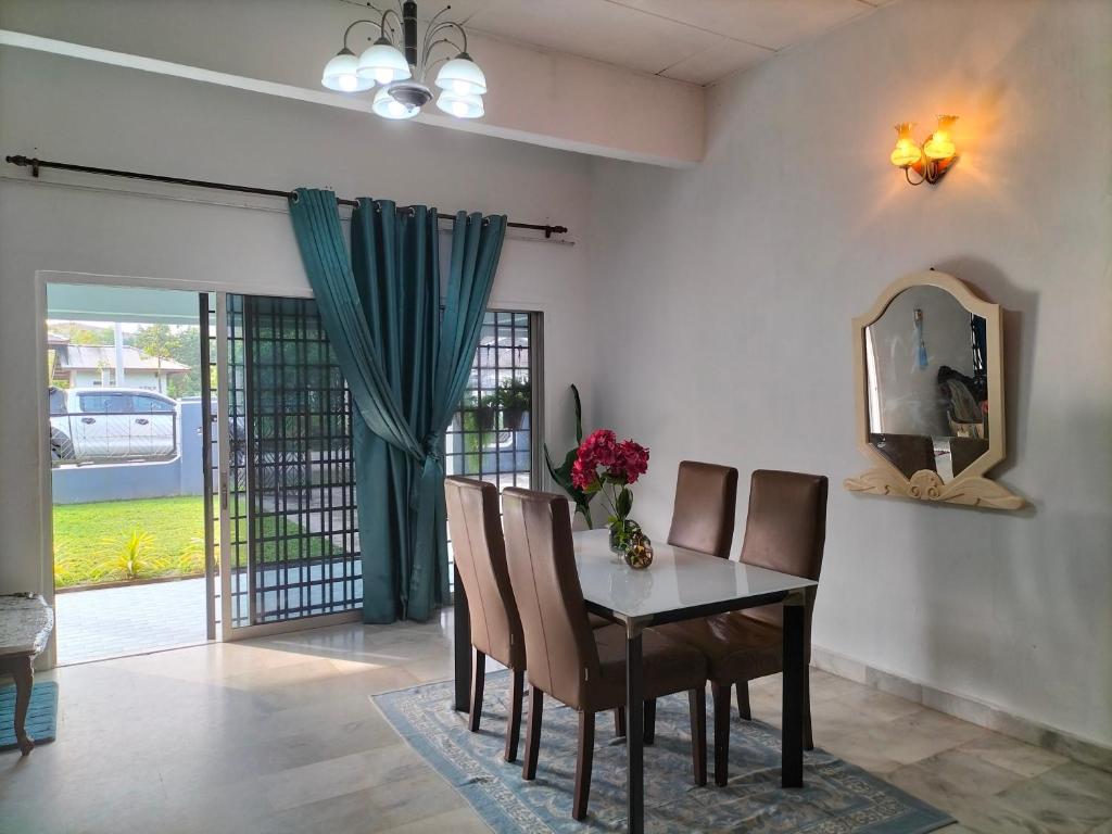 Kampong Parit TengahD'Aman Guesthouse Pontian的一间带桌椅和镜子的用餐室