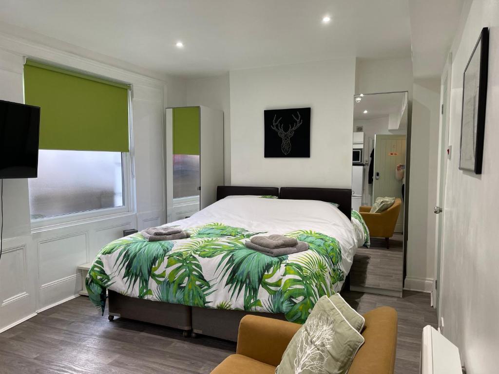 伦敦米尔德梅路公寓的一间卧室配有一张带绿色和白色毯子的床