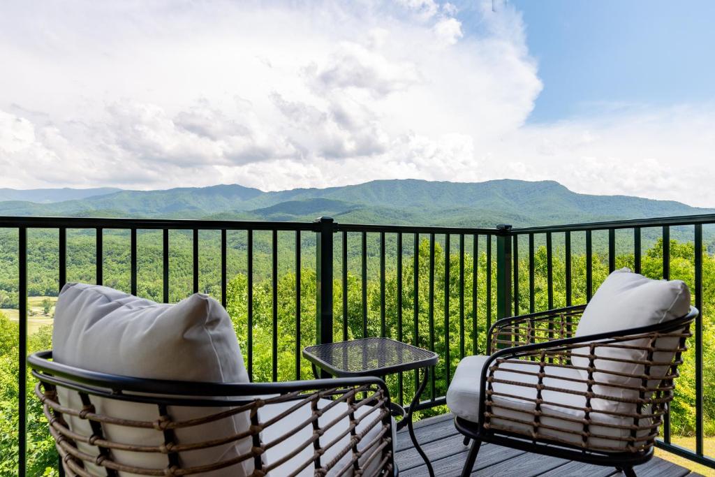 加特林堡Deer Ridge Mountain Resort A201的阳台配有2把椅子和1张桌子,享有山景。