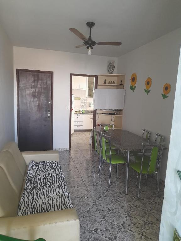 瓜拉派瑞Ap 300m praia do morro的客厅配有桌子和绿色椅子