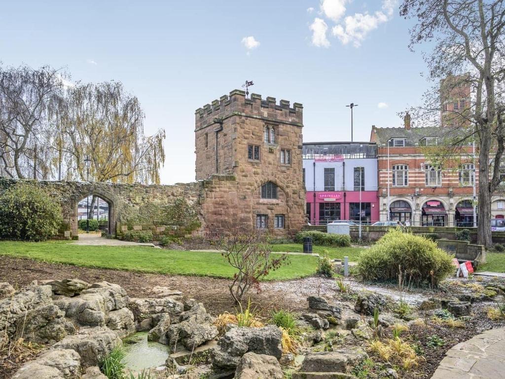 考文垂Swanswell Gate的一座古老的石头建筑,前面有一个花园