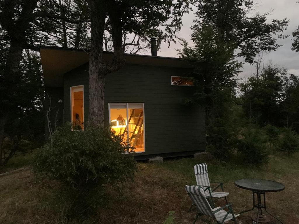 科伊艾科Tiny House, Cabaña的房屋前设有两把椅子和一张桌子