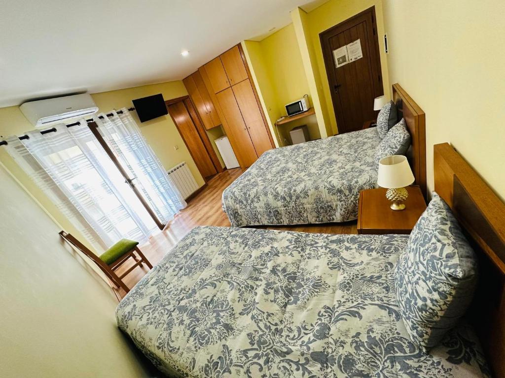 吉尔斯Residência Iris的酒店客房,配有两张床和椅子