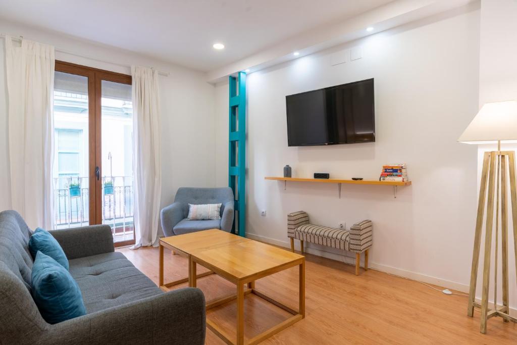 塞维利亚Locksmith Apartment -Wifi- Park Option的带沙发、桌子和电视的客厅