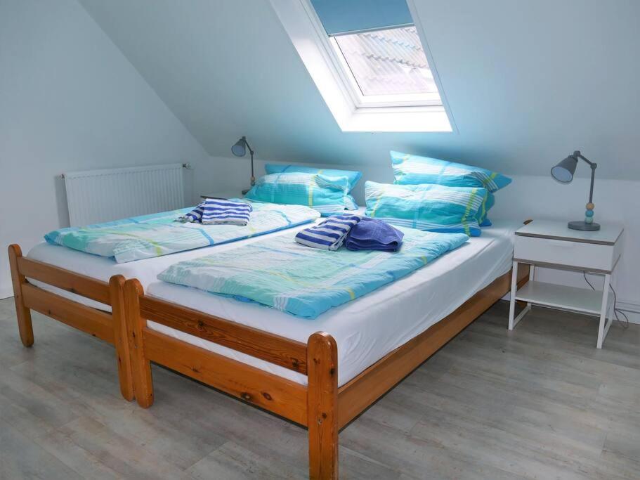 朗格奥Ferienwohnung: Utkiek的一间卧室配有一张带蓝色枕头的床和一扇窗户。