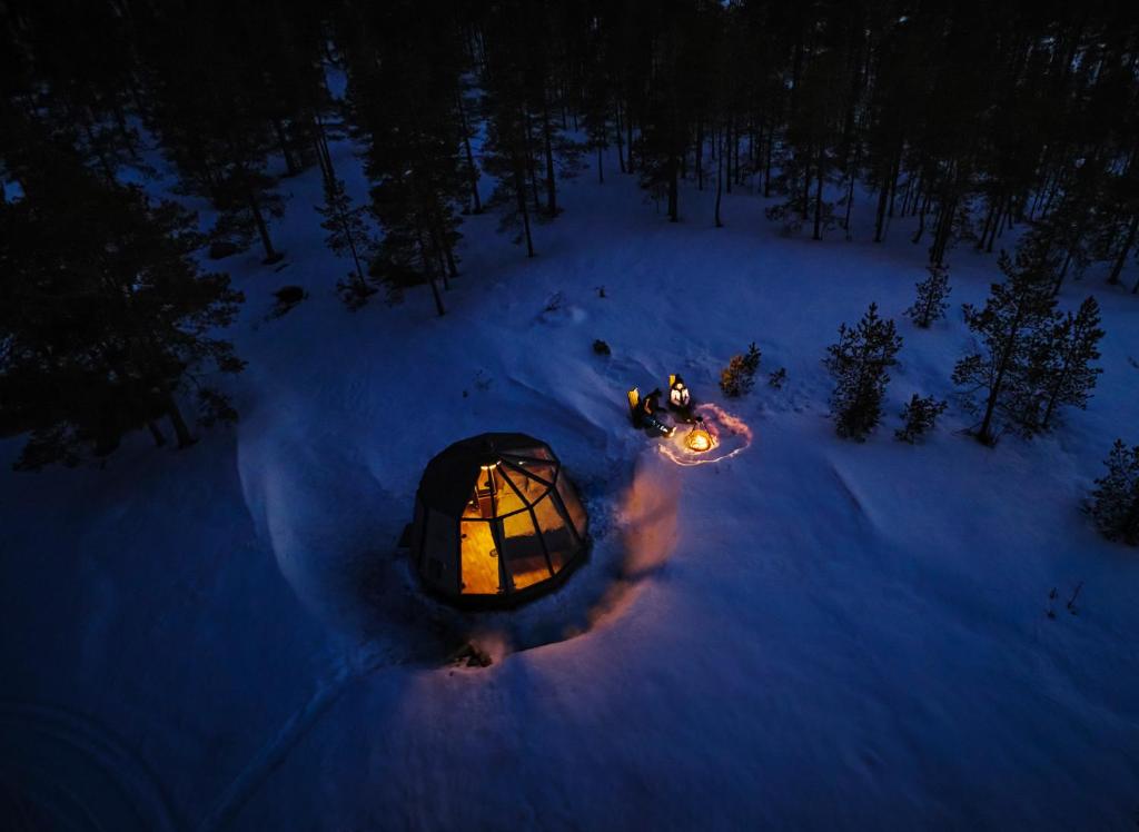 皮特奥Northern Lodges的夜晚雪地圆顶帐篷的顶部景色