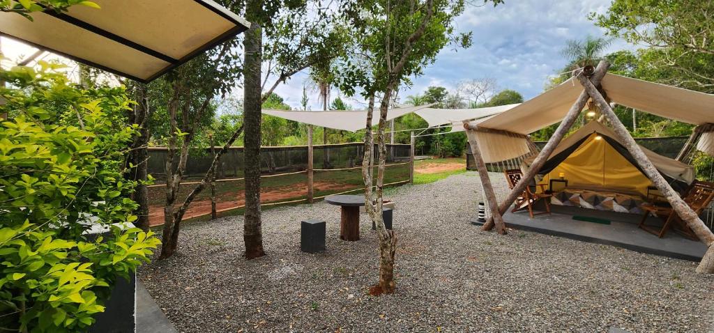 皮里韦维El Paraje Camping的院子内带桌子和长凳的帐篷