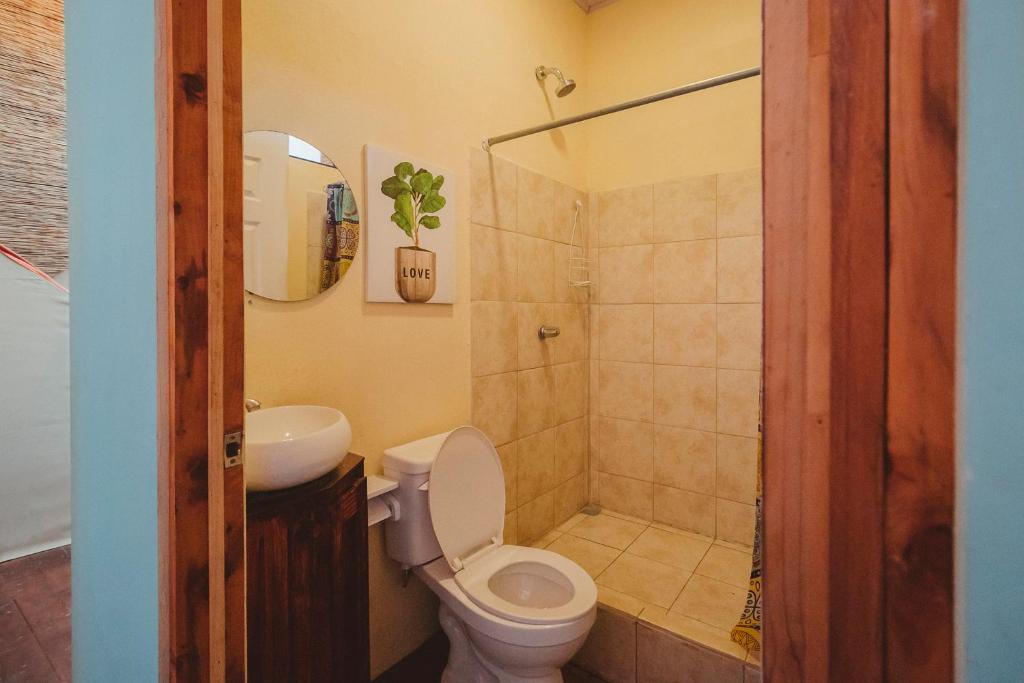 圣塔特蕾莎海滩Habitat Surf Glamp的浴室配有卫生间、盥洗盆和淋浴。