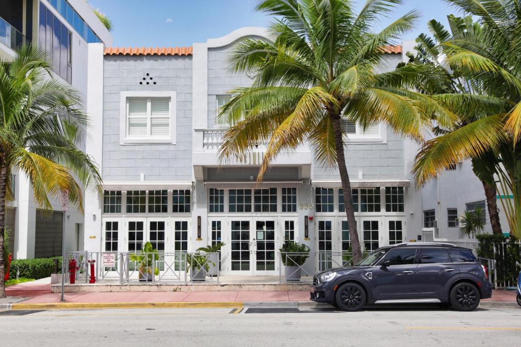 迈阿密海滩The Julia Hotel的棕榈树建筑前的停车场