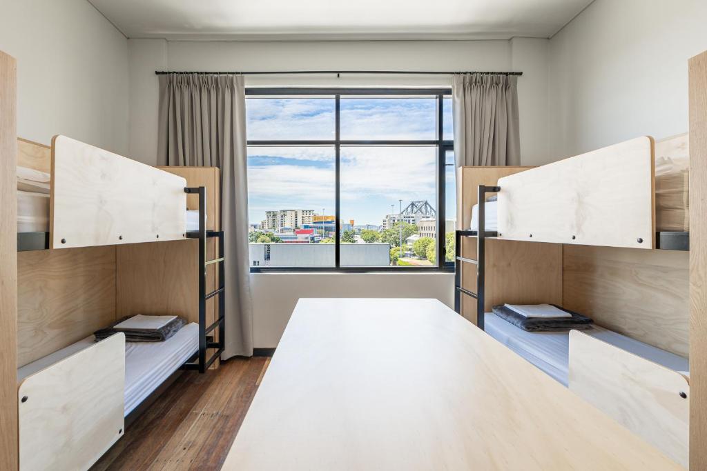 布里斯班布里斯班双层床旅舍的一间卧室设有双层床和大窗户