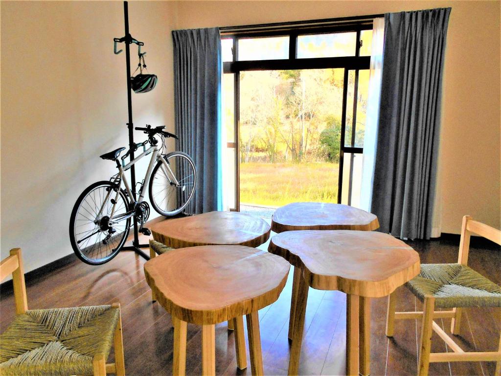 ゲストハウスみちしお的一间设有四张木桌和自行车的房间