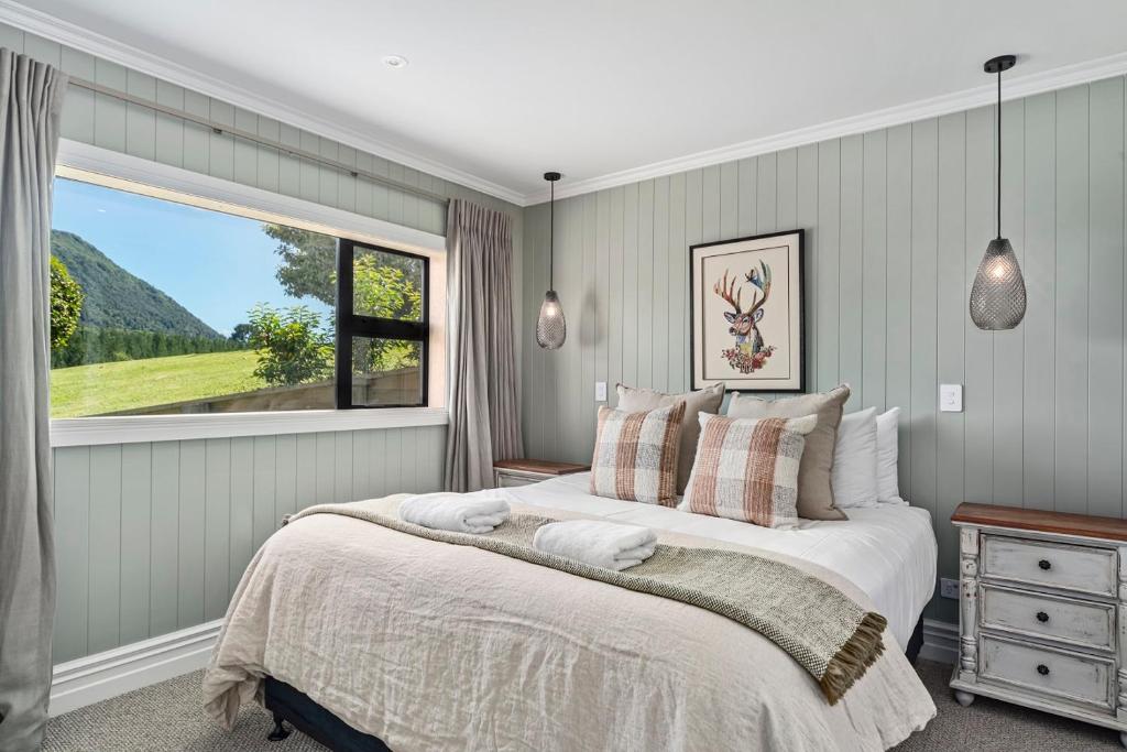 陶波Stagford Retreat Apartment - Taupo的一间卧室设有一张大床和一个窗户。