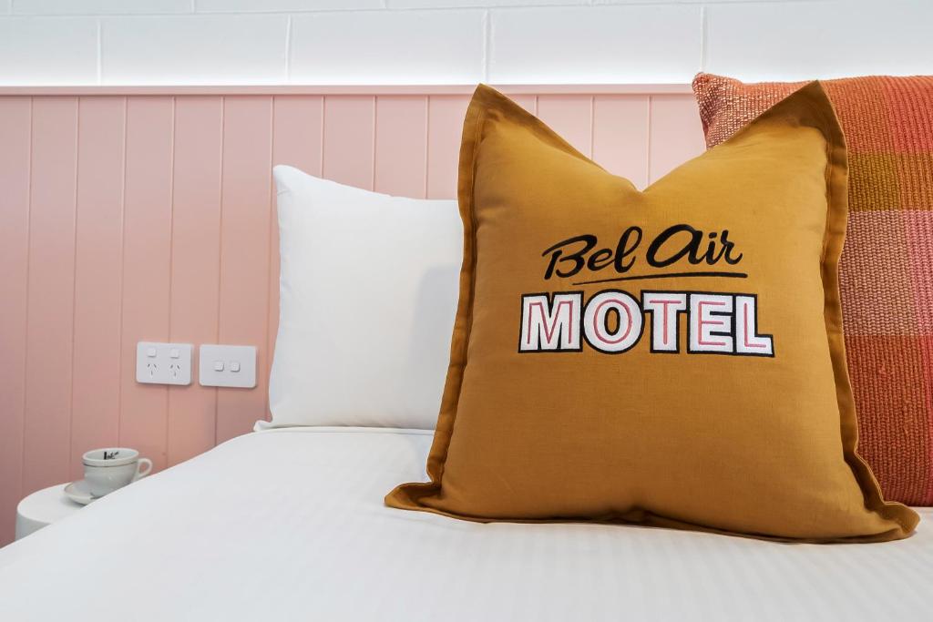 麦凯Bel Air Motel的配有枕头的床,拥有文字床艺术汽车旅馆
