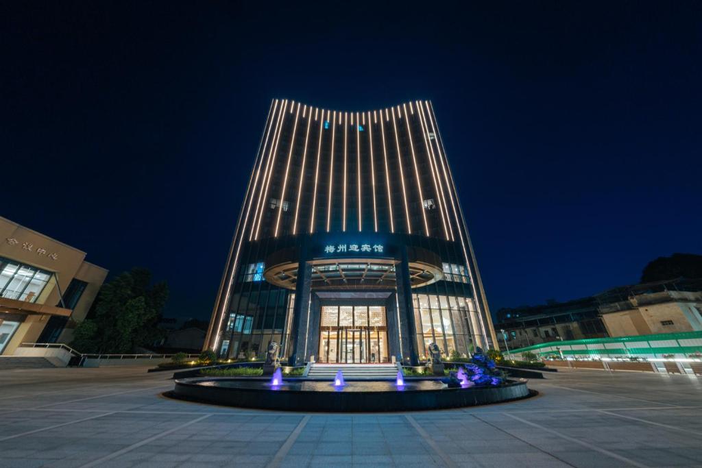 梅州梅州白天鹅迎宾馆的一座建筑,在晚上前方有一个喷泉