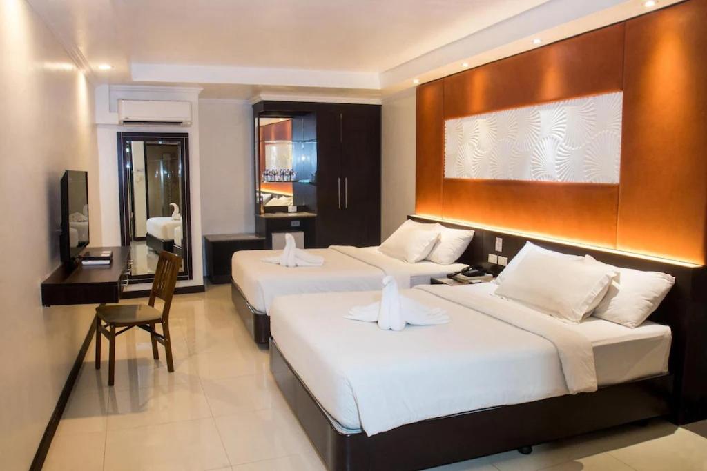 宿务M Citi Suites的酒店客房配有两张床和一张书桌