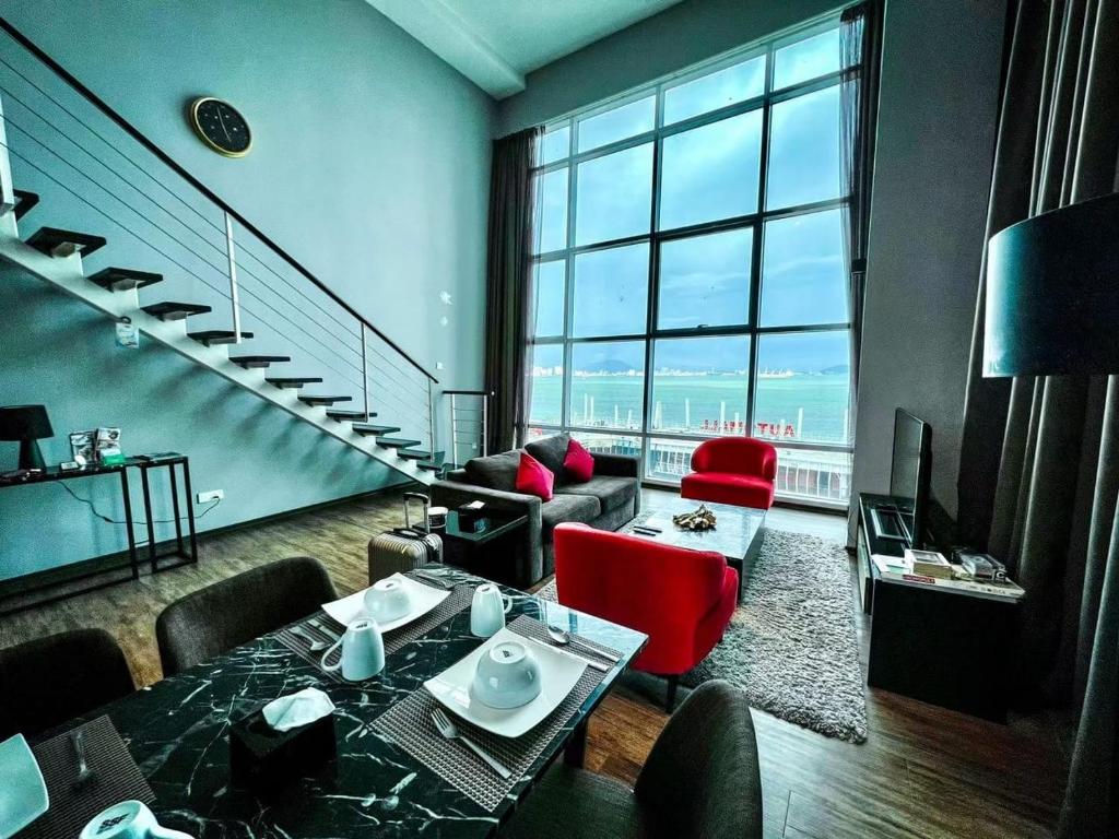 乔治市Urbano Luxury Maritime Suite的一间带楼梯和红色椅子的客厅