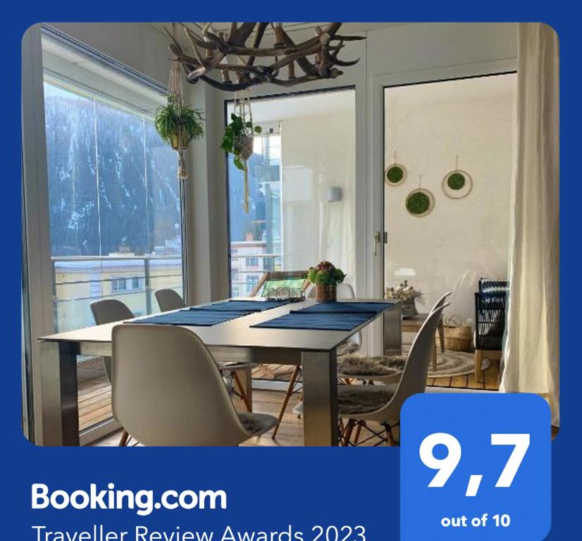 达沃斯Apartment Bellania的一间带桌椅和窗户的用餐室