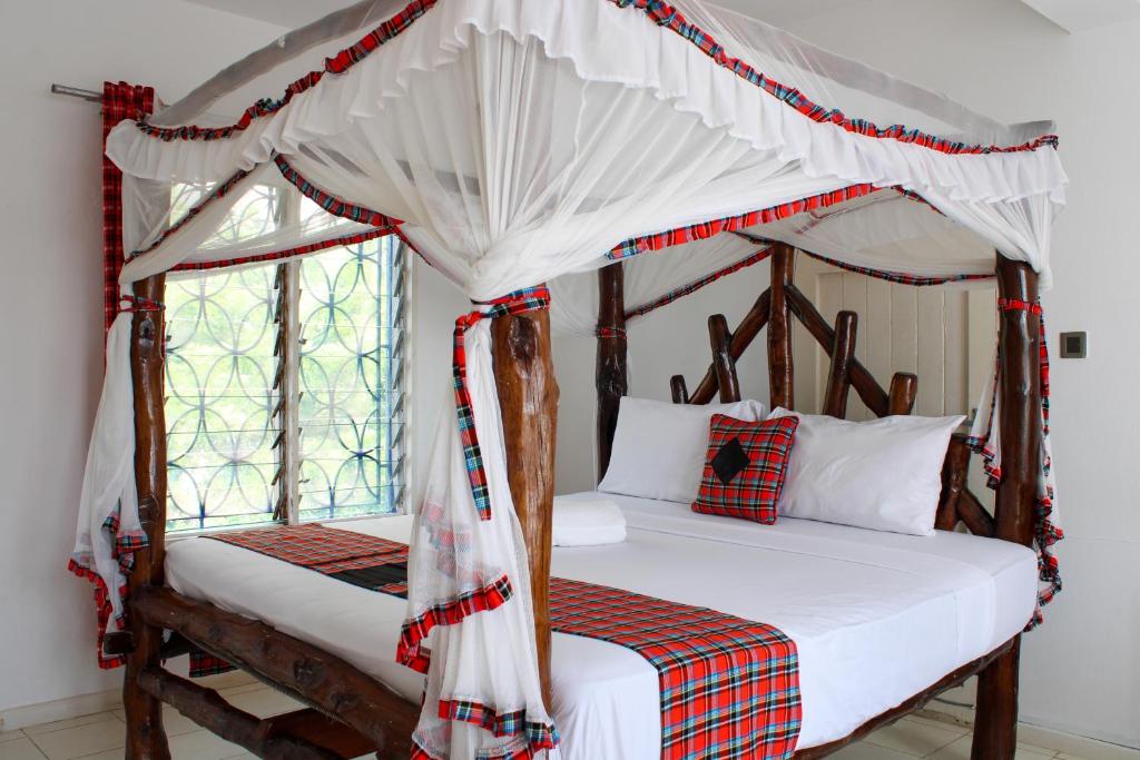 蒙巴萨The Beach House by Maasai的卧室设有两张床和一张天蓬床