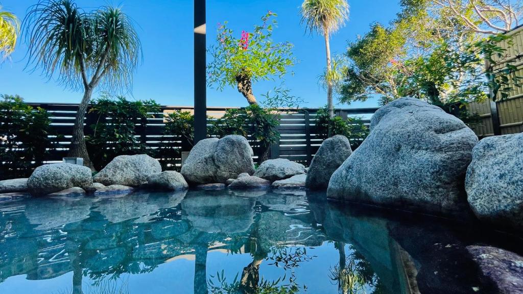 宫崎青岛太阳阁格兰蒂亚路线酒店的一片种有岩石和棕榈树的海水