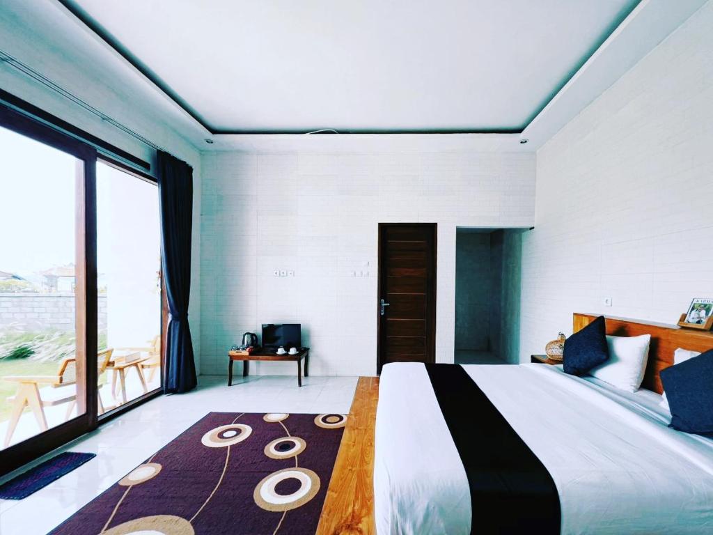 金塔马尼Mahadanu Villa & Glamping的一间卧室设有一张大床和大窗户