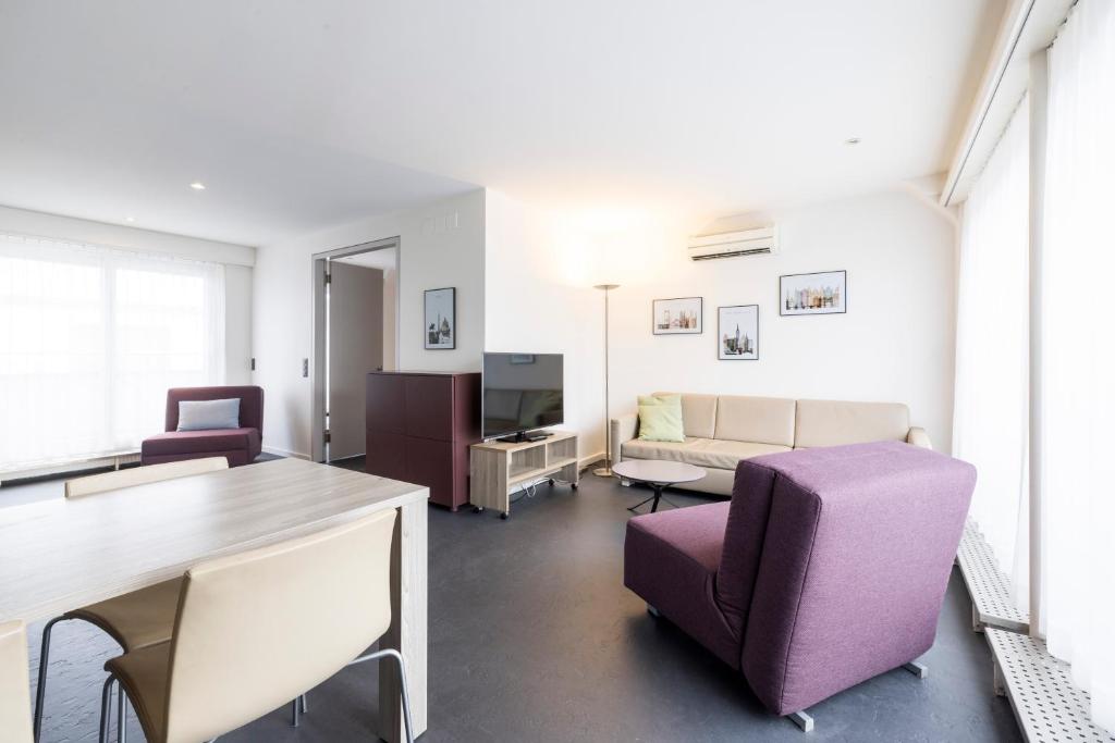 苏黎世EMA House Serviced Apartments Seefeld的客厅配有沙发和桌椅